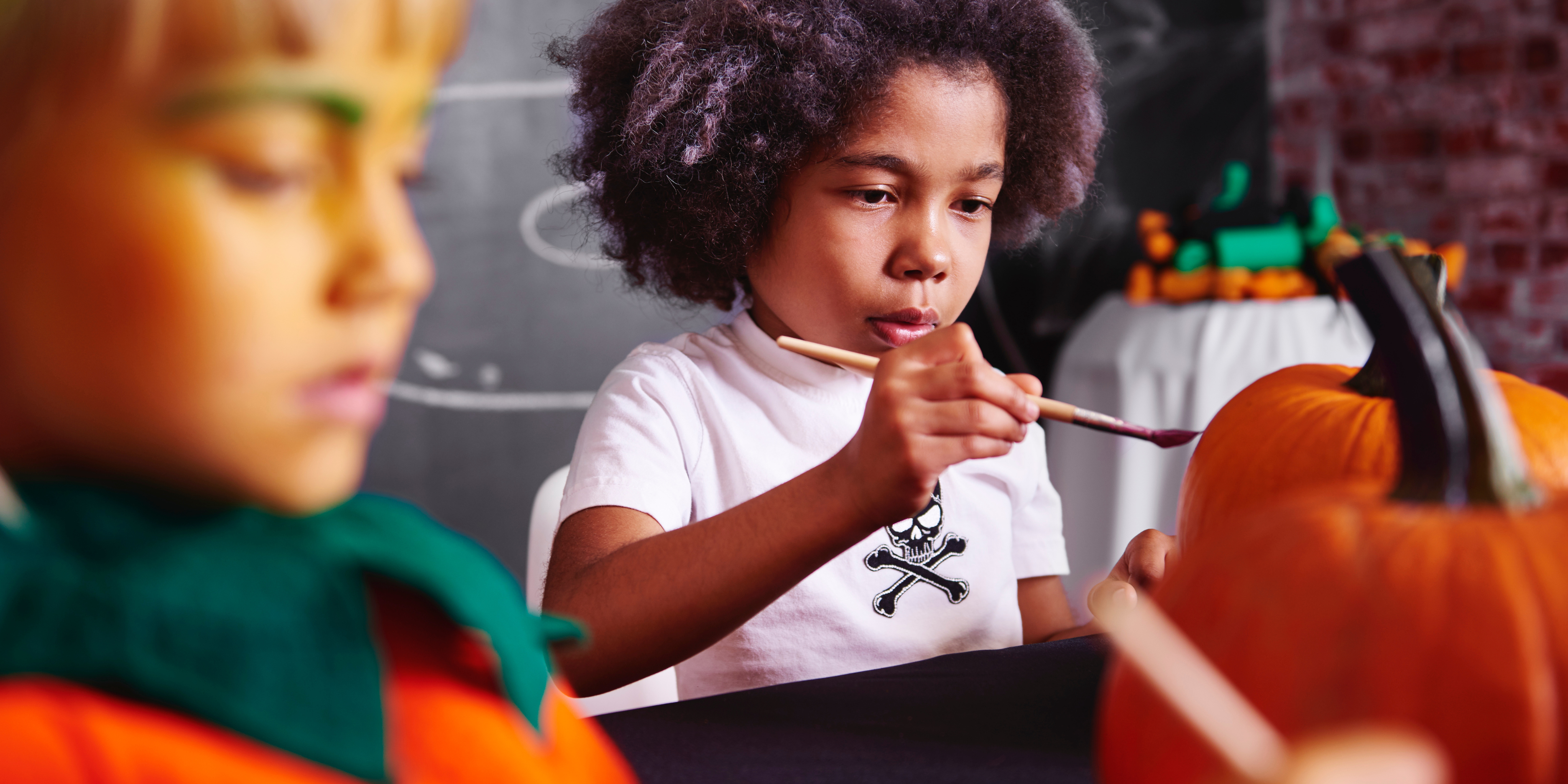 Children decorating jack-o'-lanterns for Halloween