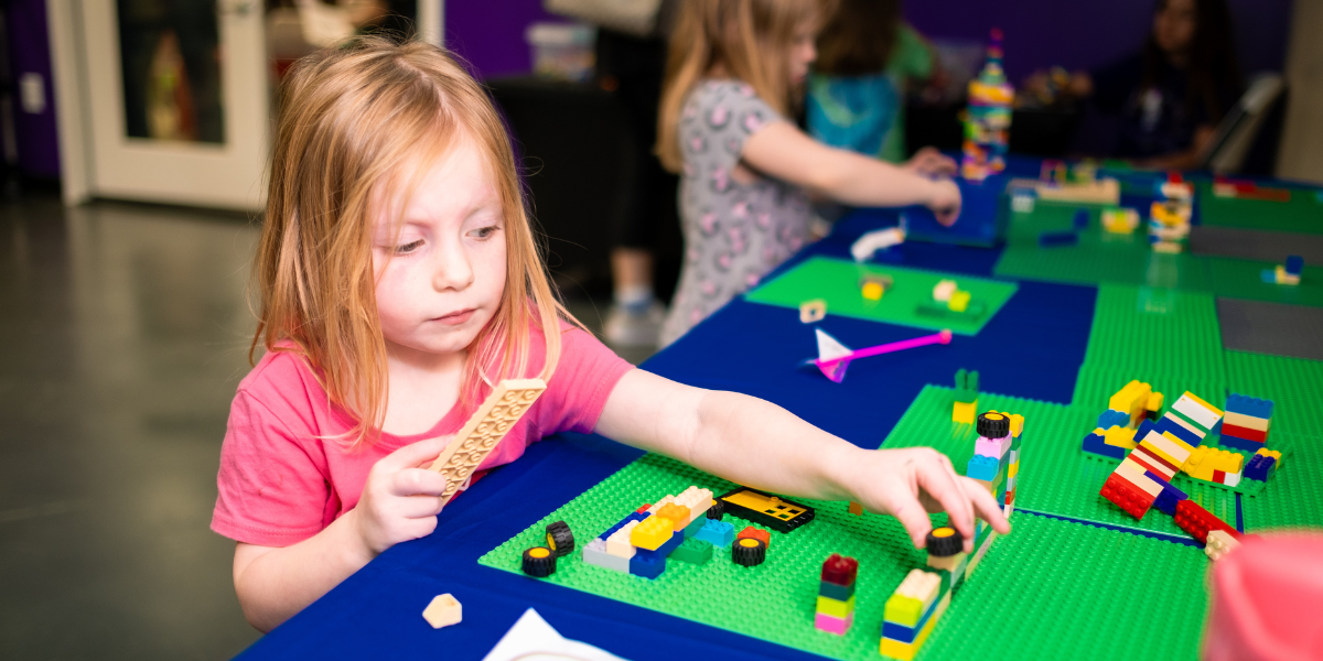 A little girl plays with colorful blocks, boosting her imagination and spatial awareness.