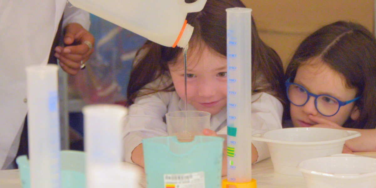 Two children focus intently on a science experiment, fostering curiosity and teamwork.