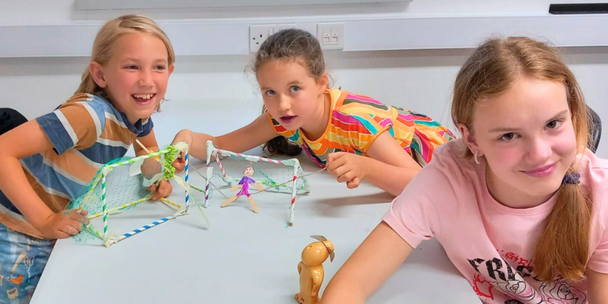 A lively group of girls explores STEM concepts through hands-on experiments, combining learning and laughter in an engaging environment.