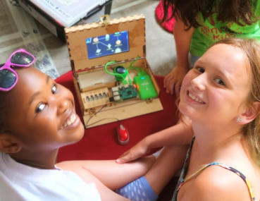 A group of girls smiles and collaborates as they tackle coding challenges, discovering the excitement and empowerment that comes with learning to program.