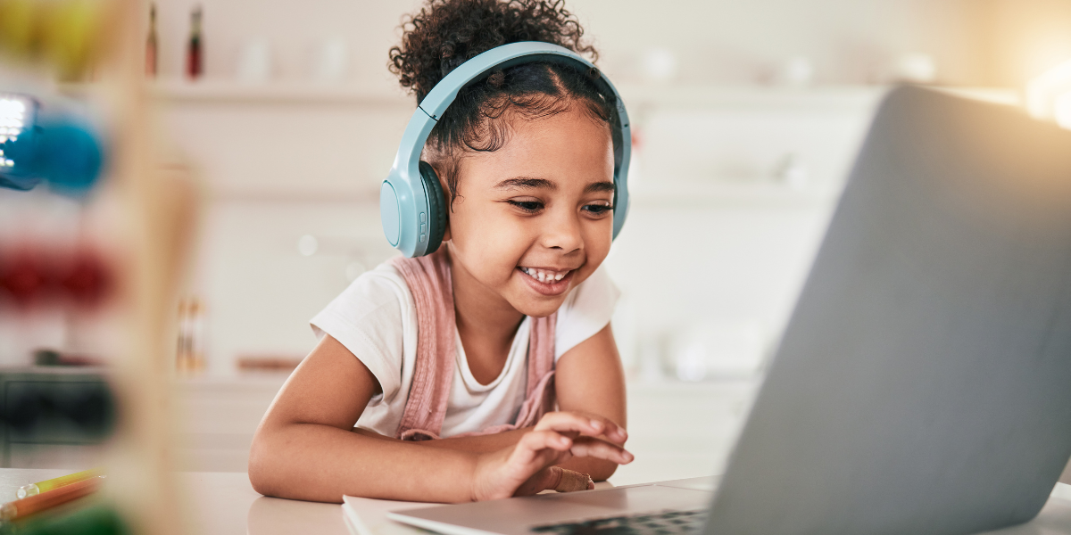 A smiling child using an affordable laptop for distance learning, ideal for schoolwork and educational apps under $400.