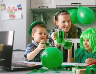 A family with two kids decorating shamrock-shaped cookies and preparing festive treats as part of kid-friendly St. Patrick's Day activities.